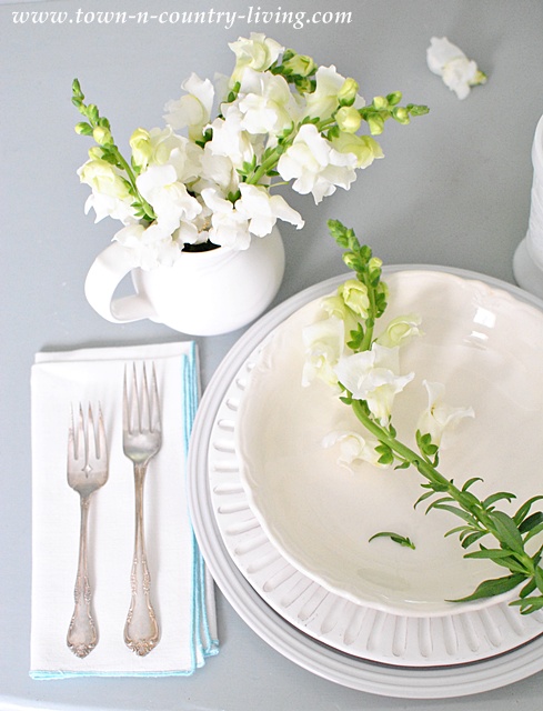 White table setting with snapdragons via Town and Country Living