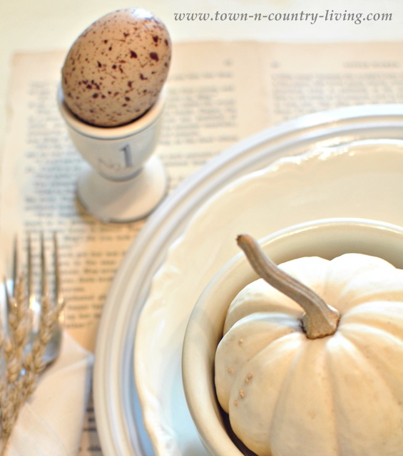 Book page placemats and white dishes via Town and Country Living's Fall Home Tour