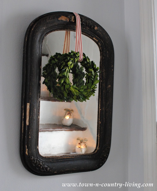 Vintage mirror with a boxwood wreath and peppermint stripe ribbon