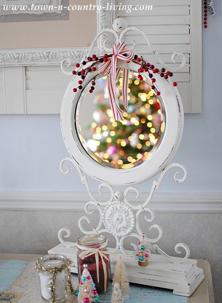 White ornate desktop mirror reflecting Christmas lights