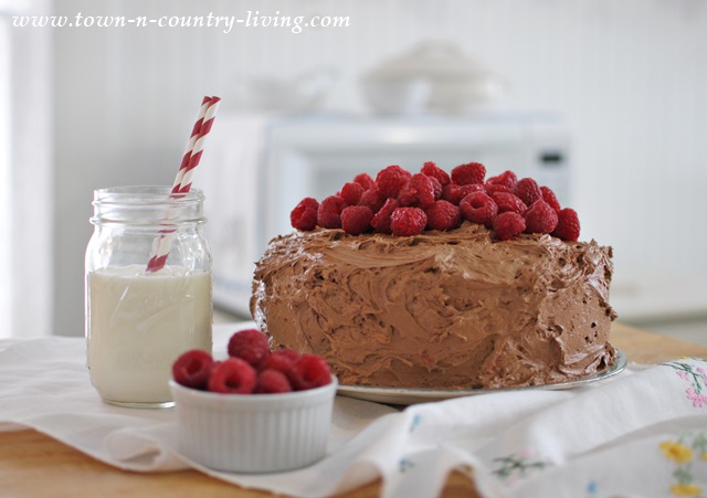 Raspberries piled high on a dark chocolate cake
