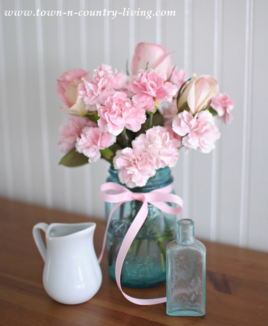 Spring decorating with pink flowers in a blue mason jar