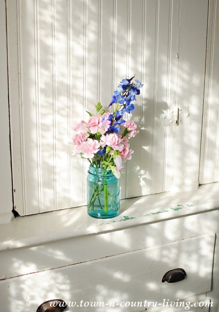 Pink and blue blooms in an aqua mason jar
