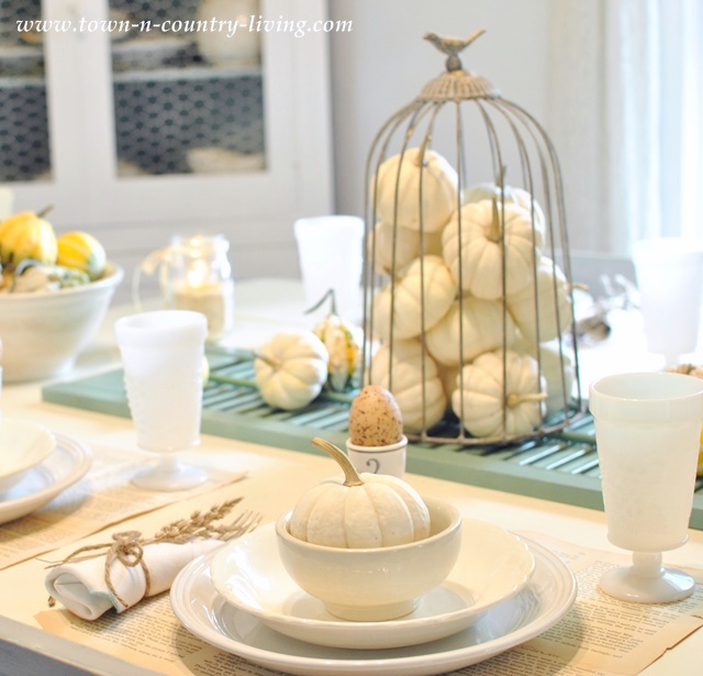 DIY Home Decor - Baby Boos in a wire cloche sit atop an old shutter and takes center stage on a Fall tablescape