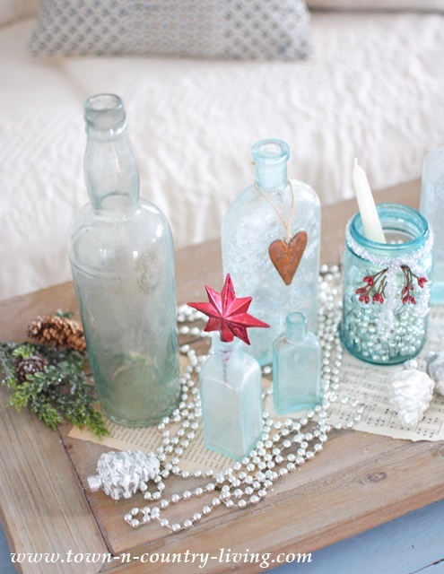 DIY Christmas Decor - create a vignette with vintage aqua bottles, touches of red, and silver glass bead garland