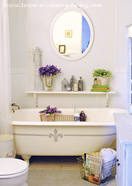 Clawfoot tub in a Farmhouse Bathroom. A fleur de lis gives it a French country touch.