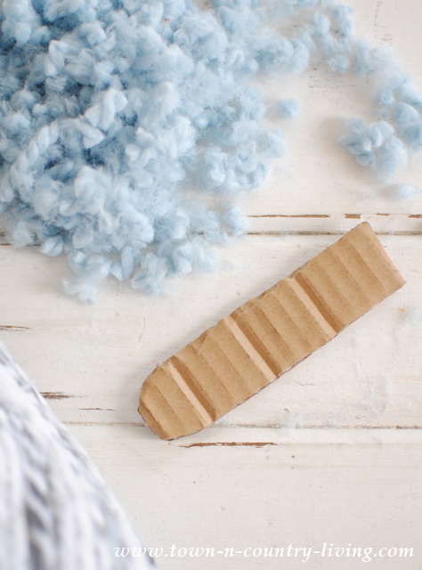 Instead of using a slippery fork to make pom poms, cut a piece of cardboard with a rounded end. The rounded end makes it easier to slip the yarn off.