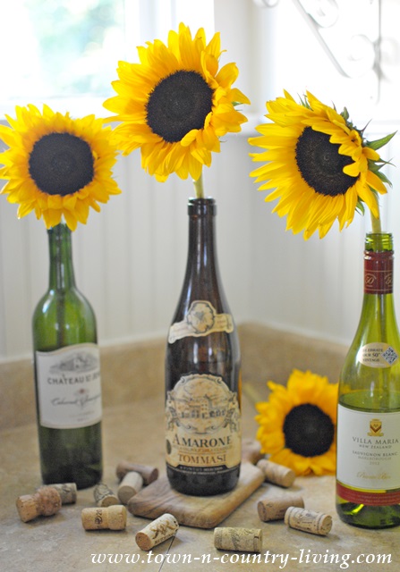 Sunflowers arranged in wine bottles